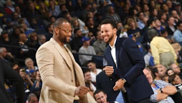 OAKLAND, CA - NOVEMBER 13: DeMarcus Cousins #0 of the Golden State Warriors and Stephen Curry #30 of the Golden State Warriors smile from the bench during the game against the Atlanta Hawks on November 13, 2018 at ORACLE Arena in Oakland, California. NOTE TO USER: User expressly acknowledges and agrees that, by downloading and or using this photograph, user is consenting to the terms and conditions of Getty Images License Agreement. Mandatory Copyright Notice: Copyright 2018 NBAE (Photo by Noah Graham/NBAE via Getty Images)