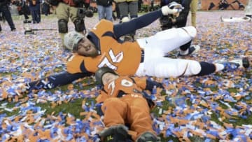 Jan 24, 2016; Denver, CO, USA; Denver Broncos tackle Tyler Polumbus (76) plays with a youngster in the confetti after the AFC Championship football game at Sports Authority Field at Mile High. Denver Broncos defeated New England Patriots 20-18 to earn a trip to Super Bowl 50. Mandatory Credit: Ron Chenoy-USA TODAY Sports