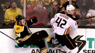 BOSTON - JANUARY 30: Boston Bruins left wing Jake DeBrusk (74) takes a hit along the boards from Anaheim Ducks' Josh Manson (42) during the first period. The Boston Bruins host the Anaheim Ducks in a regular season NHL hockey game at TD Garden in Boston on Jan. 30, 2018. (Photo by Barry Chin/The Boston Globe via Getty Images)