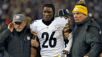 Nov 28, 2013; Baltimore, MD, USA; Pittsburgh Steelers running back LeVeon Bell (26) is led off the field by team staff after has his helmet was knocked off in the fourth quarter against the Baltimore Ravens during a NFL football game on Thanksgiving at M&T Bank Stadium. Mandatory Credit: Mitch Stringer-USA TODAY Sports