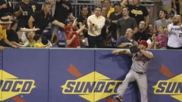 Aug 26, 2014; Pittsburgh, PA, USA; Fans scramble for a home run ball hit by Pittsburgh Pirates third baseman Josh Harrison (not pictured) as St. Louis Cardinals left fielder Matt Holliday (7) looks on during the fifth inning at PNC Park. Mandatory Credit: Charles LeClaire-USA TODAY Sports