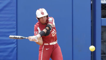 Jun 6, 2021; Oklahoma City, Oklahoma, USA; Oklahoma 2b/3b Tiare Jennings (23) hits in the WomenÕs College World Series semi finals game against James Madison at USA Softball Hall of Fame Stadium. Oklahoma won 6-3. Mandatory Credit: Alonzo Adams-USA TODAY Sports