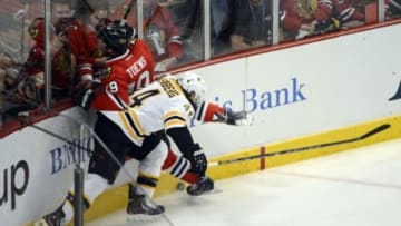 Jun 12, 2013; Chicago, IL, USA; Chicago Blackhawks center Jonathan Toews (19) is checked into the glass by Boston Bruins defenseman Dennis Seidenberg (44) during the first period in game one of the 2013 Stanley Cup Final at the United Center. Mandatory Credit: Scott Stewart-USA TODAY Sports