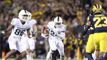 ANN ARBOR, MI - OCTOBER 07: Gerald Holmes #24 of the Michigan State Spartans runs for a first down during the second quarter of the game against the Michigan Wolverines at Michigan Stadium on October 7, 2017 in Ann Arbor, Michigan. Michigan State defeated Michigan 14-10.(Photo by Leon Halip/Getty Images)