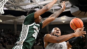 Nov 12, 2021; East Lansing, Michigan, USA; Western MichiganÕs Markeese Hastings (0) gets a shot blocked by Michigan StateÕs Marcus Bingham Jr (30) at Jack Breslin Student Events Center. Mandatory Credit: Dale Young-USA TODAY Sports