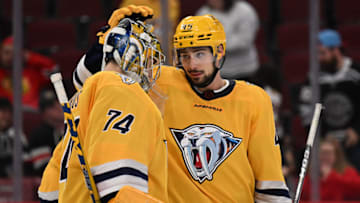 Nashville Predators goaltender Juuse Saros (74) and defenseman Alexandre Carrier (45) celebrate their 4-2 win over the Chicago Blackhawks at United Center. Mandatory Credit: Jamie Sabau-USA TODAY Sports