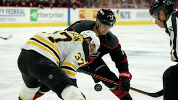 RALEIGH, NC - MAY 14: Sebastian Aho #20 of the Carolina Hurricanes and Patrice Bergeron #37 of the Boston Bruins meet in the faceoff in Game Three of the Eastern Conference Third Round during the 2019 NHL Stanley Cup Playoffs on May 14, 2019 at PNC Arena in Raleigh, North Carolina. (Photo by Gregg Forwerck/NHLI via Getty Images)