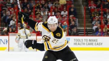Dec 23, 2016; Raleigh, NC, USA; Boston Bruins defensemen Brandon Carlo (25) gets ready to take a slap shot against the Carolina Hurricanes at PNC Arena. The Carolina Hurricanes defeated the Boston Bruins 3-2 in overtime. Mandatory Credit: James Guillory-USA TODAY Sports