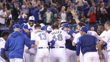 TORONTO, ON - SEPTEMBER 20: Justin Smoak #14 of the Toronto Blue Jays is congratulated by teammates at home plate after hitting a game-winning solo home run in the ninth inning during MLB game action against the Tampa Bay Rays at Rogers Centre on September 20, 2018 in Toronto, Canada. (Photo by Tom Szczerbowski/Getty Images)