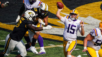 LSU Tigers quarterback Myles Brennan (15) throws a pass as Missouri Tigers linebacker Trajan Jeffcoat (18) defends during the second half at Faurot Field at Memorial Stadium. Mandatory Credit: Jay Biggerstaff-USA TODAY Sports