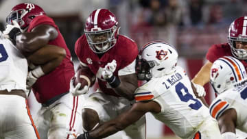 Nov 28, 2020; Tuscaloosa, Alabama, USA; Alabama running back Brian Robinson Jr. (4) is tackled by Auburn linebacker Zakoby McClain (9) at Bryant-Denny Stadium in the Iron Bowl. Mandatory Credit: Mickey Welsh/The Montgomery Advertiser via USA TODAY Sports