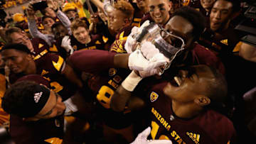 TEMPE, AZ - NOVEMBER 25: Running back Trelon Smith #19 (R) of the Arizona State Sun Devils celebrate with the territorial cup after defeating the Arizona Wildcats in college football game at Sun Devil Stadium on November 25, 2017 in Tempe, Arizona. The Sun Devils defeated the Wildcats 42-30. (Photo by Christian Petersen/Getty Images)