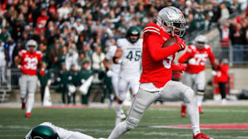 Sat., Nov. 20, 2021; Columbus, Ohio, USA; Ohio State Buckeyes wide receiver Garrett Wilson (5) breaks a tackle on his way to a touchdown during the first quarter of a NCAA Division I football game between the Ohio State Buckeyes and the Michigan State Spartans at Ohio Stadium. Mandatory Credit: Joshua A. Bickel/Columbus Dispatch via USA TODAY Network.Cfb Michigan State Spartans At Ohio State Buckeyes