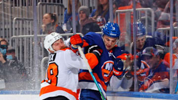 ELMONT, NEW YORK - JANUARY 17: Adam Pelech #3 of the New York Islanders is checked into the boards by Claude Giroux #28 of the Philadelphia Flyers during the first period at the UBS Arena on January 17, 2022 in Elmont, New York. (Photo by Bruce Bennett/Getty Images)
