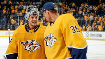 NASHVILLE, TN - OCTOBER 13: Pekka Rinne #35 congratulates Juuse Saros #74 of the Nashville Predators after a 5-2 win against the New York Islanders at Bridgestone Arena on October 13, 2018 in Nashville, Tennessee. (Photo by John Russell/NHLI via Getty Images)