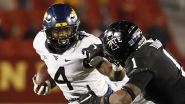 AMES, IA - DECEMBER 5: Running back Leddie Brown #4 of the West Virginia Mountaineers rushes for yards as defensive back Isheem Young #1 of the Iowa State Cyclones defends in the second half of play at Jack Trice Stadium on December 5, 2020 in Ames, Iowa. The Iowa State Cyclones won 42-6 over the West Virginia Mountaineers. (Photo by David K Purdy/Getty Images)