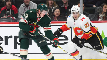 MINNEAPOLIS, MN - DECEMBER 12: Minnesota Wild Defenceman Gustav Olofsson (23) chips the puck into the zone as Calgary Flames Right Wing Garnet Hathaway (21) gives chase during a NHL game between the Minnesota Wild and Calgary Flames on December 12, 2017 at Xcel Energy Center in St. Paul, MN.The Wild defeated the Flames 2-1 in a shootout.(Photo by Nick Wosika/Icon Sportswire via Getty Images)
