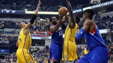 Mar 1, 2015; Indianapolis, IN, USA; Philadelphia 76ers forward Luc Mbah a Moute (12) takes a shot against Indiana Pacers center Roy Hibbert (55) and forward David West (21) at Bankers Life Fieldhouse. Mandatory Credit: Brian Spurlock-USA TODAY Sports