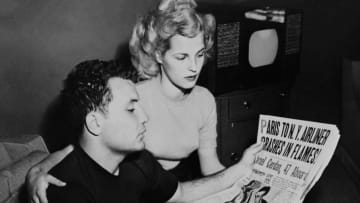 Photo taken on October 31, 1949 shows US boxer Jake LaMotta (L) and his wife Vikki reading the newspaper announcing the death of Marcel Cerdan just as he is due to fight him for the World Middleweight title. / AFP PHOTO / - (Photo credit should read -/AFP/Getty Images)