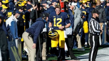 Michigan quarterback Cade McNamara talks to head coach Jim Harbaugh during the first half against Penn State at Michigan Stadium in Ann Arbor, Saturday, Nov. 28, 2020.