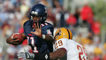 TUCSON, AZ - NOVEMBER 26: Mike Bell #11 of Arizona tries to escape the tackle of Robert James #29 of Arizona State in the 2nd quarter at Arizona Stadium on November 26, 2004 in Tucson, Arizona. Arizona would go on to win 34-27. (Photo by Harry How/Getty Images)