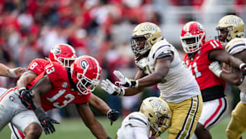 ATHENS, GA - NOVEMBER 26: Zach Gibson #15 of the Georgia Tech Yellow Jackets goes down under pressure by Mykel Williams #13 and MJ Sherman #8 of the Georgia Bulldogs during a game between Georgia Tech Yellow Jackets and Georgia Bulldogs at Sanford Stadium on November 26, 2022 in Athens, Georgia. (Photo by Steve Limentani/ISI Photos/Getty Images)