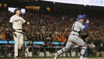 Oct 14, 2021; San Francisco, California, USA; San Francisco Giants first baseman Wilmer Flores (41) reacts after being called out on strikes as Los Angeles Dodgers catcher Will Smith (16) celebrates in the ninth inning during game five of the 2021 NLDS at Oracle Park. Mandatory Credit: D. Ross Cameron-USA TODAY Sports