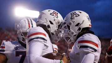 Nov 5, 2022; Salt Lake City, Utah, USA; Arizona Wildcats quarterback Jayden de Laura (center) celebrates scoring a touchdown with teammates in a game against the Utah Utes during the first quarter at Rice-Eccles Stadium. Mandatory Credit: Rob Gray-USA TODAY Sports