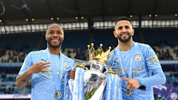 MANCHESTER, ENGLAND - MAY 23: Raheem Sterling and Riyad Mahrez of Manchester City celebrate with the Premier League Trophy as Manchester City are presented with the Trophy as they win the league following the Premier League match between Manchester City and Everton at Etihad Stadium on May 23, 2021 in Manchester, England. A limited number of fans will be allowed into Premier League stadiums as Coronavirus restrictions begin to ease in the UK. (Photo by Michael Regan/Getty Images)