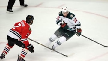 May 4, 2014; Chicago, IL, USA; Minnesota Wild right wing Nino Niederreiter (22) chases the puck with Chicago Blackhawks defenseman Brent Seabrook (7) during game two of the second round of the 2014 Stanley Cup Playoffs at United Center. Mandatory Credit: Jerry Lai-USA TODAY Sports