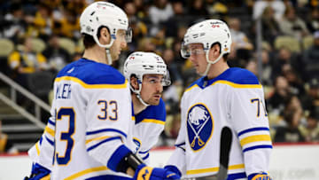 PITTSBURGH, PENNSYLVANIA - DECEMBER 17: Colin Miller #33, Brett Murray #57 and Victor Olofsson #71 of the Buffalo Sabres talk during the third period of a game against the Pittsburgh Penguins at PPG PAINTS Arena on December 17, 2021 in Pittsburgh, Pennsylvania. (Photo by Emilee Chinn/Getty Images)