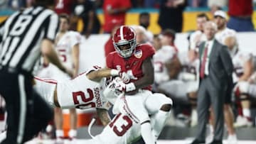 MIAMI, FL - DECEMBER 29: Jerry Jeudy #4 of the Alabama Crimson Tide makes the catch on the defense of Tre Norwood #13 and Robert Barnes #20 of the Oklahoma Sooners in the second quarter during the College Football Playoff Semifinal against the Oklahoma Sooners at the Capital One Orange Bowl at Hard Rock Stadium on December 29, 2018 in Miami, Florida. (Photo by Jamie Squire/Getty Images)