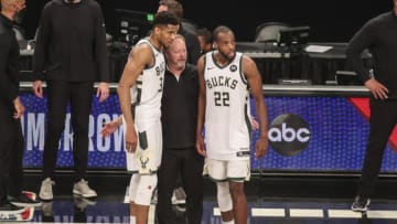Jun 19, 2021; Brooklyn, New York, USA; Milwaukee Bucks head coach Mike Budenholzer stands with forward Giannis Antetokounmpo (34) and forward Khris Middleton (22) after defeating the Brooklyn Nets in overtime in game seven in the second round of the 2021 NBA Playoffs at Barclays Center. Mandatory Credit: Wendell Cruz-USA TODAY Sports