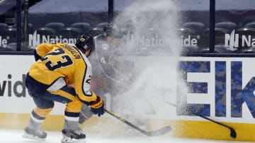 Feb 18, 2021; Columbus, Ohio, USA; Columbus Blue Jackets defenseman Scott Harrington (4) and Nashville Predators right wing Rocco Grimaldi (23) battle for the puck along the boards during the second period at Nationwide Arena. Mandatory Credit: Russell LaBounty-USA TODAY Sports