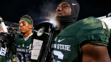Nov 28, 2015; East Lansing, MI, USA; Michigan State Spartans cornerback Arjen Colquhoun (36) and cornerback Jermaine Edmondson (39) carry the Big Ten east championship trophy after a game at Spartan Stadium. Mandatory Credit: Mike Carter-USA TODAY Sports