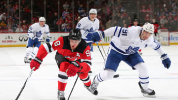 NEWARK, NJ - DECEMBER 18: John Tavares #91 of the Toronto Maple Leafs and Taylor Hall #9 of the New Jersey Devils skate after the puck during the first period at the Prudential Center on December 18, 2018 in Newark, New Jersey. (Photo by Andy Marlin/NHLI via Getty Images)