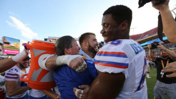 Jan 2, 2017; Tampa , FL, USA; Florida Gators head coach Jim McElwain (C) hugs defensive lineman Joey Ivie (91) and offensive lineman Richerd Desir-Jones (68) after defeating the Iowa Hawkeyes 30-3 at Raymond James Stadium. Florida Mandatory Credit: Kim Klement-USA TODAY Sports