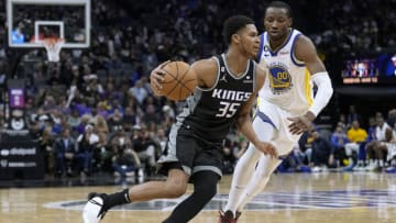 SACRAMENTO, CALIFORNIA - APRIL 07: PJ Dozier #35 of the Sacramento Kings dribbles past Jonathan Kuminga #00 of the Golden State Warriors during the fourth quarter of an NBA basketball game at Golden 1 Center on April 07, 2023 in Sacramento, California.NOTE TO USER: User expressly acknowledges and agrees that, by downloading and or using this photograph, User is consenting to the terms and conditions of the Getty Images License Agreement. (Photo by Thearon W. Henderson/Getty Images)
