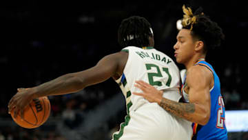 Jrue Holiday #21 of the Milwaukee Bucks dribbles the ball against Tre Mann #23 of the Oklahoma City Thunder in the first half during a preseason game at Fiserv Forum on October 10, 2021 in Milwaukee, Wisconsin. NOTE TO USER: User expressly acknowledges and agrees that, by downloading and or using this photograph, user is consenting to the terms and conditions of the Getty Images License Agreement. (Photo by Patrick McDermott/Getty Images)