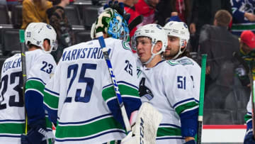 DETROIT, MI - OCTOBER 22: Troy Stecher #51 of the Vancouver Canucks congratulates teammate goaltender Jacob Markstrom #25 following an NHL game against the Detroit Red Wings at Little Caesars Arena on October 22, 2019 in Detroit, Michigan. Vancouver defeated Detroit 5-2. (Photo by Dave Reginek/NHLI via Getty Images)