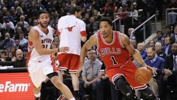 Nov 13, 2014; Toronto, Ontario, CAN; Chicago Bulls guard Derrick Rose (1) dribbles past Toronto Raptors |guard Greivis Vasquez (21) during the second quarter at Air Canada Centre. Chicago won 100 - 93. Mandatory Credit: Peter Llewellyn-USA TODAY Sports