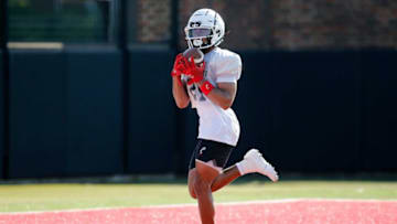 Bearcats receiver Tyler Scott catches a pass during preseason training camp. The Enquirer.
