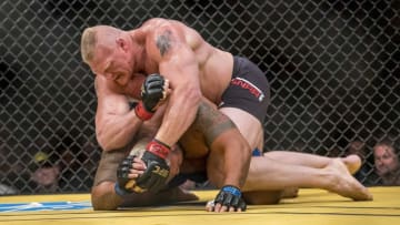 Jul 9, 2016; Las Vegas, NV, USA; Mark Hunt (blue gloves) is elbowed by Brock Lesnar (red gloves) during UFC 200 at T-Mobile Arena. Mandatory Credit: Joshua Dahl-USA TODAY Sports