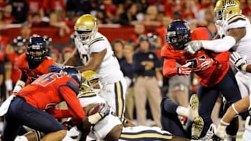Nov 9, 2013; Tucson, AZ, USA; UCLA Bruins linebacker Myles Jack (30) gets tripped up during the second quarter against the Arizona Wildcats at Arizona Stadium. Mandatory Credit: Casey Sapio-USA TODAY Sports