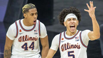Illinois Fighting Illini guard Andre Curbelo (5) gets fans pumped up as teammate Adam Miller (44) cheers Curbelo's shot against Iowa Hawkeyes on Saturday, March 13, 2021, during the men's Big Ten basketball tournament from Lucas Oil Stadium.Iowa Vs Illinois