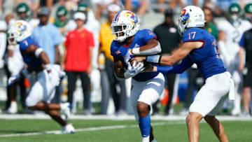 Kansas Jayhawks redshirt junior quarterback Jason Bean (17) hands the ball off to freshman running back Devin Neal (4) in the first half of Saturday's game against the Baylor Bears at David Booth Kansas Memorial Stadium.