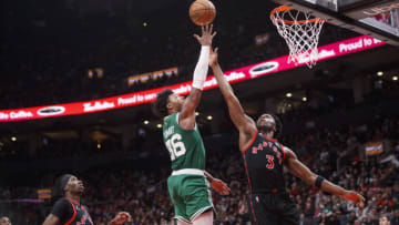 TORONTO, ON - MARCH 28: Marcus Smart #36 of the Boston Celtics drives to the net against OG Anunoby #3 and Chris Boucher #25 of the Toronto Raptors (Photo by Cole Burston/Getty Images)