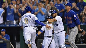 Apr 3, 2016; Kansas City, MO, USA; Kansas City Royals base runner Mike Moustakas (8) celebrates after scoring with teammate Kendrys Morales (25) after scoring, as New York Mets pitcher Matt Harvey (33) looks on during the first inning at Kauffman Stadium. Mandatory Credit: Peter G. Aiken-USA TODAY Sports