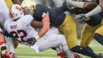 Oct 4, 2014; South Bend, IN, USA; Stanford Cardinal running back Remound Wright (22) is tackled by Notre Dame Fighting Irish linebacker Joe Schmidt (38) in the third quarter at Notre Dame Stadium. Notre Dame won 17-14. Mandatory Credit: Matt Cashore-USA TODAY Sports