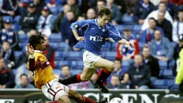 18 Mar 2000: Neil McCann of Glasgow Rangers jumps over a challenge from Benito Kemble of Motherwell during the Scottish Premier Division match at Ibrox Stadium in Glasgow, Scotland. Glasgow Rangers won the match 6-2. Mandatory Credit: Michael Cooper /Allsport